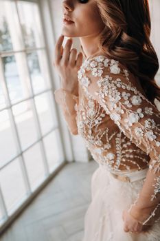 A luxurious bride in a wedding dress in the morning in her interior.