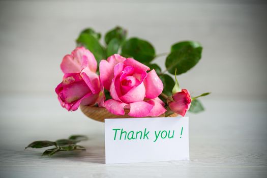 pink beautiful summer roses on a light wooden table