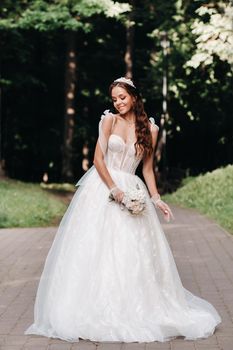 portrait of an elegant bride in a white dress with a bouquet in nature in a nature Park.Model in a wedding dress and gloves and with a bouquet .Belarus.