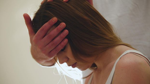 Massage session - flexing the cervical vertebrae and head of female, backlight, close up