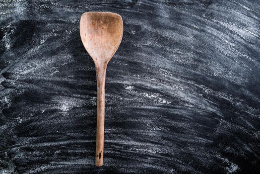 wooden spoon on a black textured table