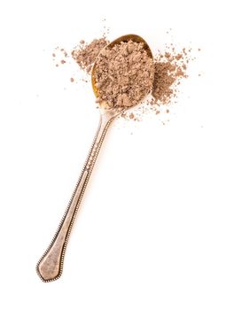 ground cinnamon powder in a spoon on a white background