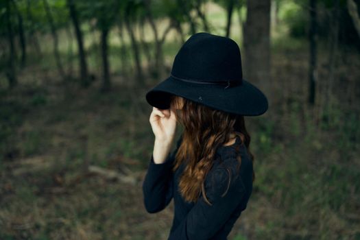 woman witch in black hat in the forest posing fantasy. High quality photo