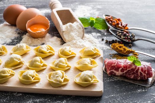 raw ravioli and different products on the black kitchen table