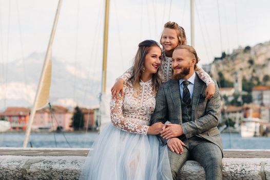 Italy, Lake Garda. Beautiful family on the shores of lake Garda in Italy at the foot of the Alps. Father, mother and daughter in Italy.