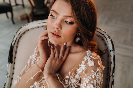 Close-up portrait of a luxurious bride in a wedding dress in the morning in her interior.