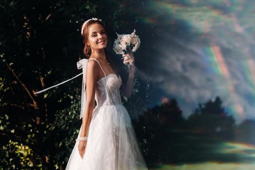 portrait of an elegant bride in a white dress with a bouquet in nature in a nature Park.Model in a wedding dress and gloves and with a bouquet .Belarus.