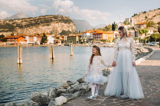 Italy, Lake Garda.Stylish Mother and daughter on the shores of lake Garda in Italy at the foot of the Alps. mother and daughter in Italy.