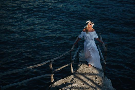 Smiling Beautiful Woman on the Beach In a Straw Hat on the island of Zakynthos.A girl in a white dress at sunset on Zakynthos island, Greece