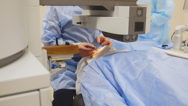 The patient lies on the operating surgical table during ophthalmology operation surgery wthout anesthesia - laser vision correction, horizontal