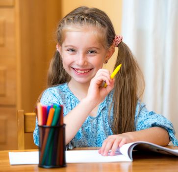 Schoolgirl with colored felt-tip pens in the classroom