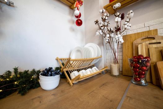 cozy kitchen decorated for Christmas. plate dryer on a wooden work surface