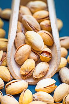 salt pistachios in a wooden spoon