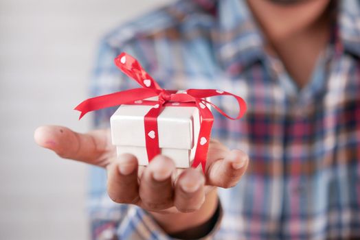 male hand holding gift box, closeup.