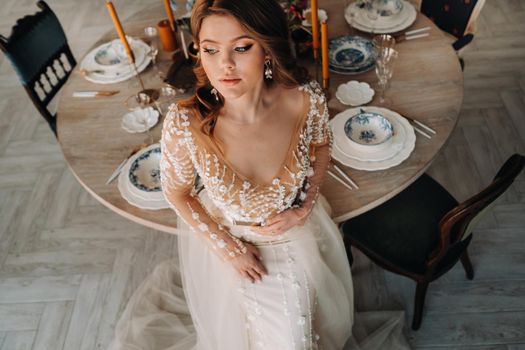 A luxurious bride in a wedding dress in the morning in her interior.