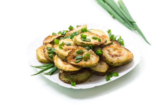 fried zucchini in circles with fresh herbs in a plate isolated on white background