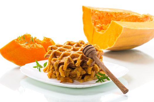 sweet baked pumpkin waffles with honey in a plate on a white background