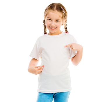 cute little girl in a white T-shirt and blue jeans on a white background shows a T-shirt on