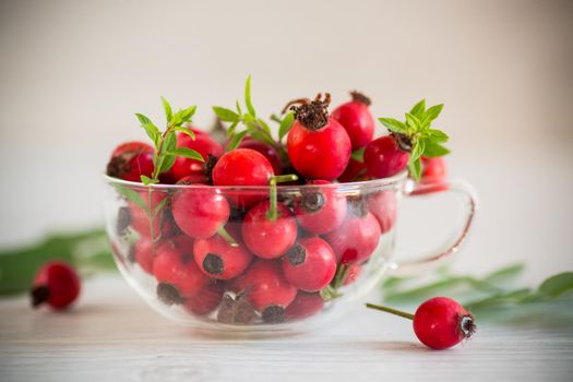 a bunch of ripe red rose hips on a wooden table