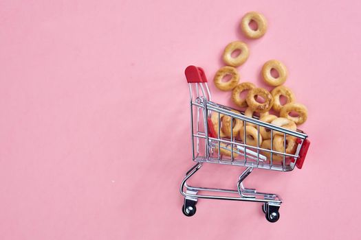 small shopping carts supermarket shopping pink background. High quality photo