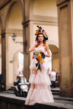 beautiful stylish girl model in a pink wedding dress photographed in Florence, holding an unusual bouquet, bride model with a bouquet in her hands, photo session of the bride in Florence