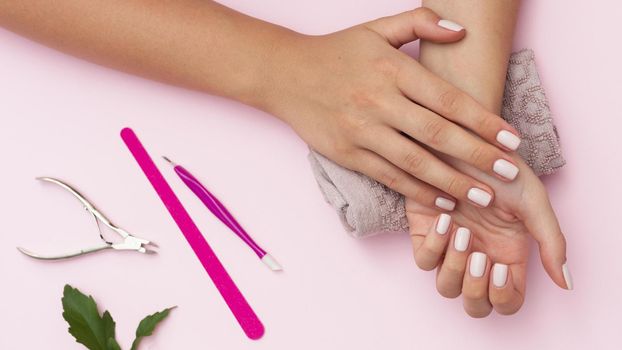 hands with manicure done and nail care tools