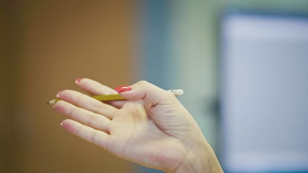 Hand gestures of Woman Office Manager when talking on the phone - manicure with bright red nails, close up, telephoto