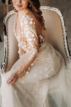 A luxurious bride in a wedding dress in the morning in her interior.