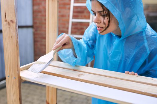 cheerful woman house painter in protective suit repairing home. High quality photo