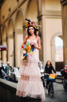 beautiful stylish girl model in a pink wedding dress photographed in Florence, holding an unusual bouquet, bride model with a bouquet in her hands, photo session of the bride in Florence