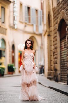 beautiful stylish girl model in a pink wedding dress photographed in Florence, holding an unusual bouquet, bride model with a bouquet in her hands, photo session of the bride in Florence