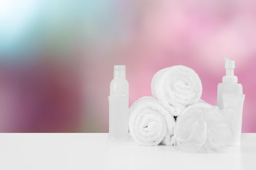 Spa still life with towels and skincare cosmetics against blurred background, close up