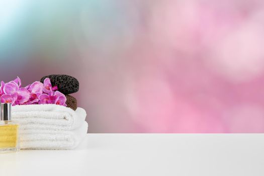 Towels with flowers on light table against blurred background, front view