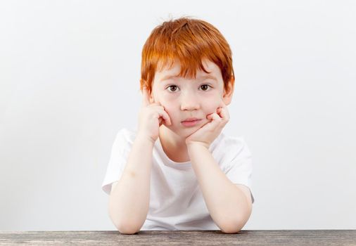 portrait of a boy with curiosity looking forward to the photographer, tired look