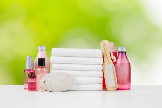 Spa still life with towels and skincare cosmetics against blurred background, close up