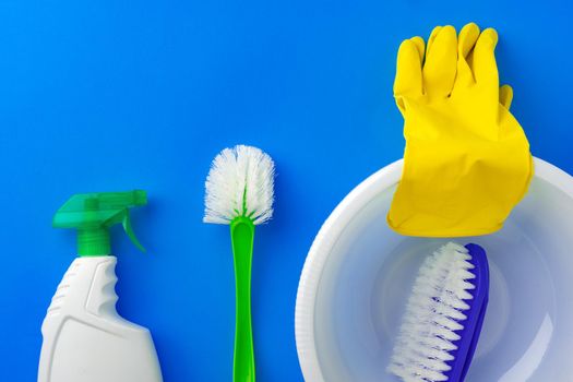 House cleaning supplies on blue color background, top view