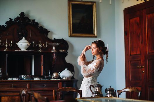 a bride in underwear and a white robe in the interior of a Villa in Italy at a wedding.morning of the bride in Tuscany.boudoir photo session at the Villa