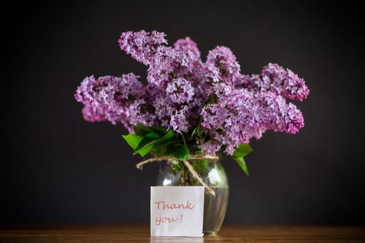 bouquet of beautiful spring lilac flowers on a wooden table