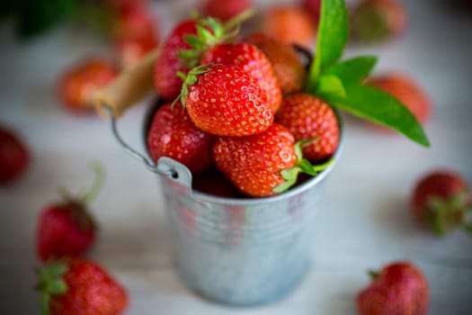 harvest of red ripe natural strawberries on a wooden table