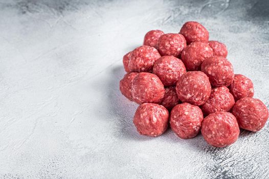 Raw beef and pork meatballs with spices on kitchen table. White background. Top view. Copy space.