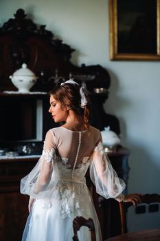 a bride in underwear and a white robe in the interior of a Villa in Italy at a wedding.morning of the bride in Tuscany.boudoir photo session at the Villa