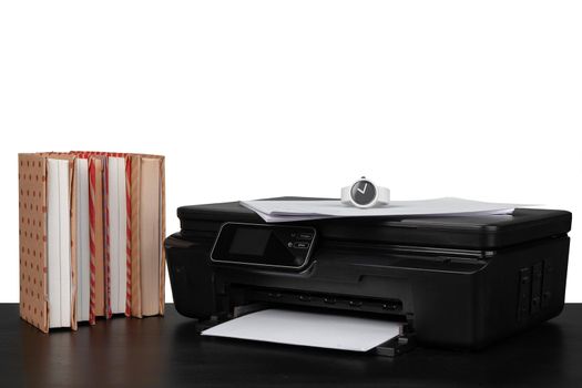 Working table with printer and stacked books on white abckground, close up