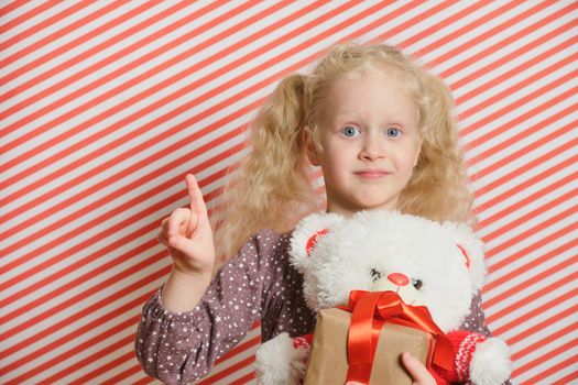 blond preschooler girl with white teddy bear m gift with red ribbon, red striped background, holiday gifts, boxing day, christmas, womens day, birthday party