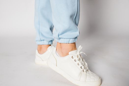 Unrecognizable young runner tying her shoelaces. Studio shot on wooden floor background.