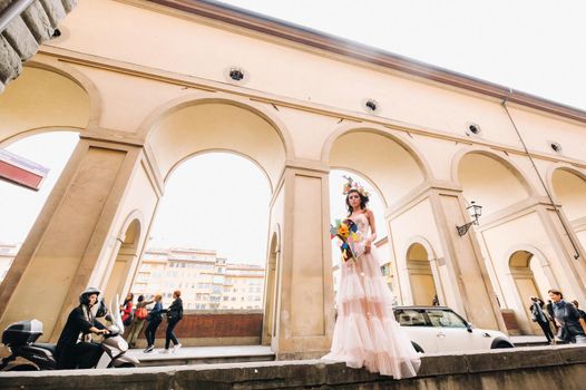 beautiful stylish girl model in a pink wedding dress photographed in Florence, holding an unusual bouquet, bride model with a bouquet in her hands, photo session of the bride in Florence