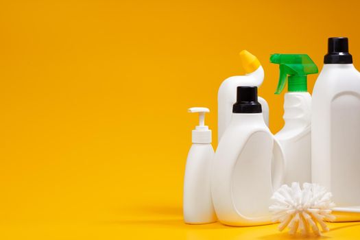 House cleaning detergent bottles on a yellow background, copy space