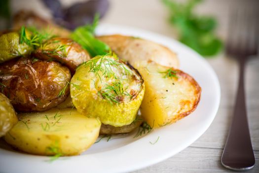 Early baked potatoes with zucchini and chicken, on a wooden table