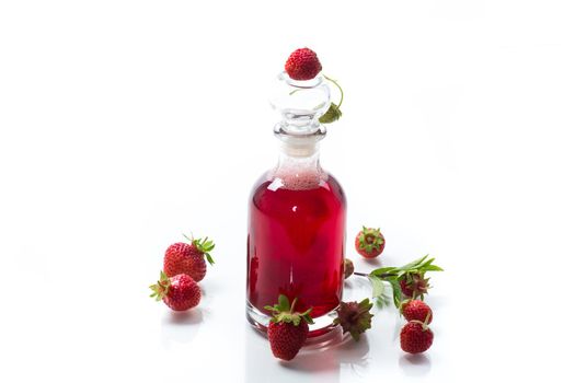sweet cooked strawberry syrup in a glass decanter isolated on white background