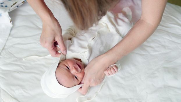 Mother is swaddling her child - newborn baby infant, close up