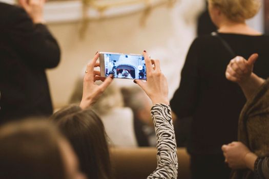 Spectators at concert - people shooting performance on smartphone, music opera, telephoto